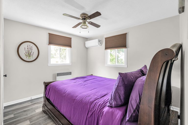 side view of bedroom with 1 queen bed