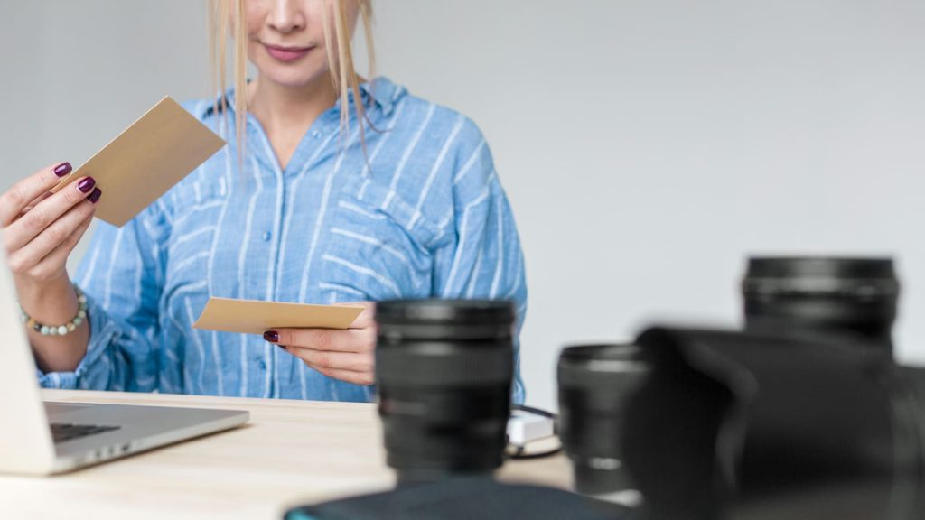 Graphic of a photographer looking at printed property photos to pick the best ones as one of the tips for Airbnb photos.